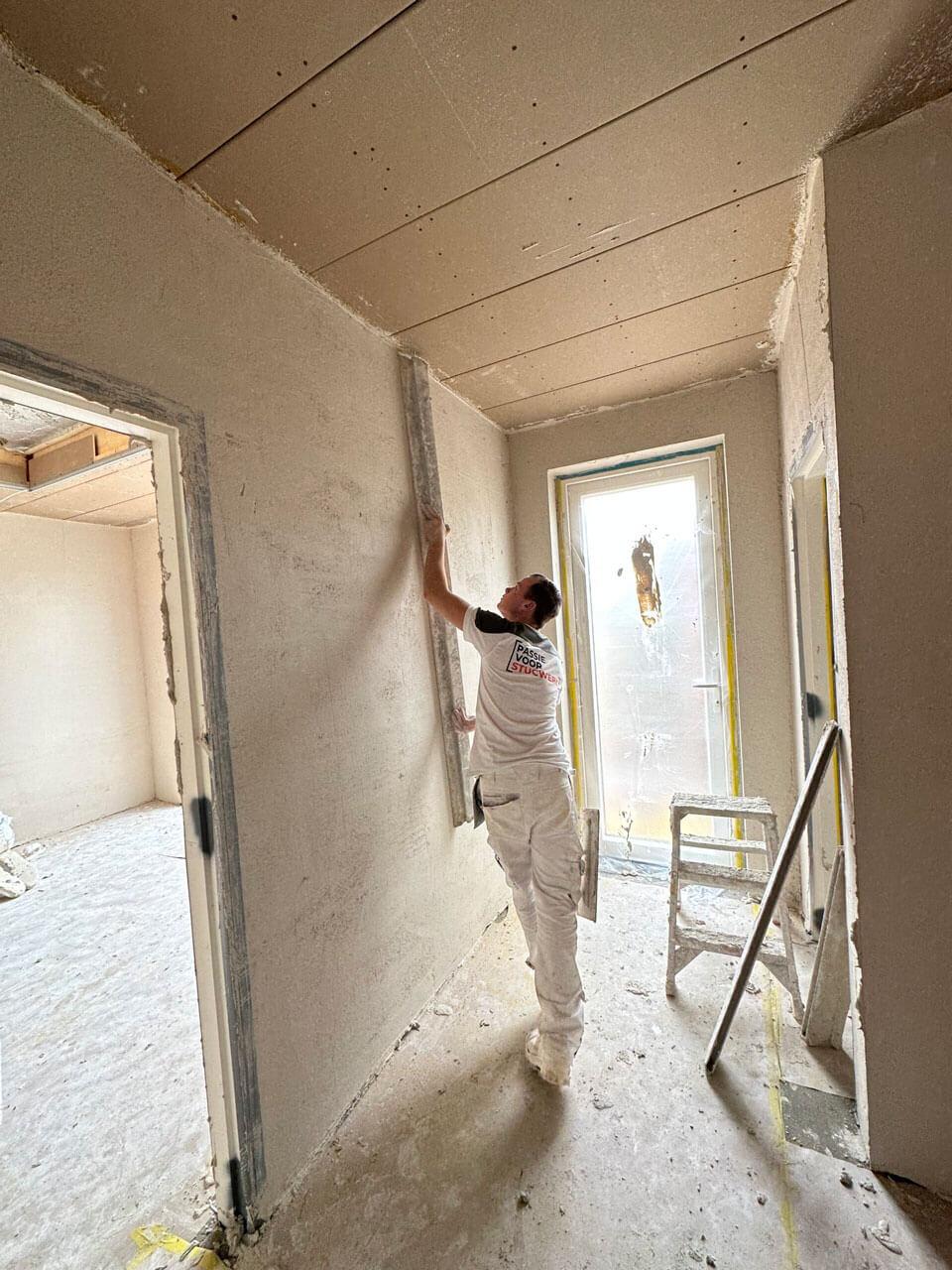 Stukadoor van Passie voor Stucwerk die een muur bewerkt met stucwerk.